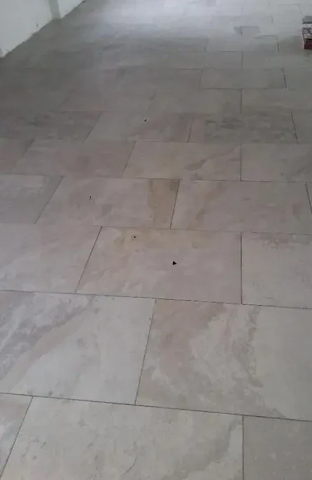 Application soignée d’une chape traditionnelle sur un sol neuf pour assurer un nivellement parfait