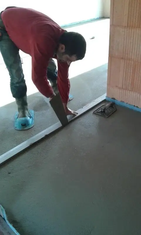 Image d’un artisan en train d’appliquer une chape au sol sur un chantier, illustrant le savoir-faire et le professionnalisme de Pro Chape Carrelage